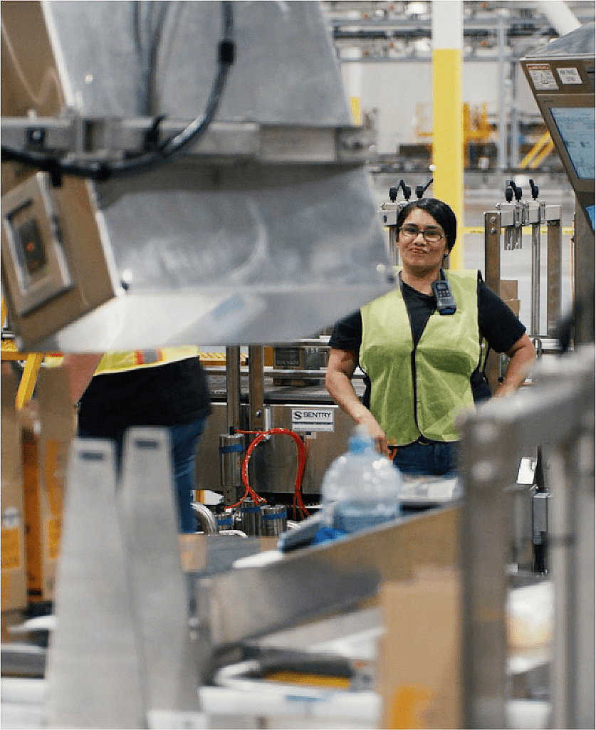 woman inside a factory smiling with hands on her hips